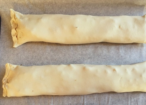 1. Этап. Штрудель яблочный из готового слоеного теста: И теперь заворачиваем тесто с начинкой в рулет. Тщательно защипываем края. Выкладываем на противень, застеленный пергаментом.