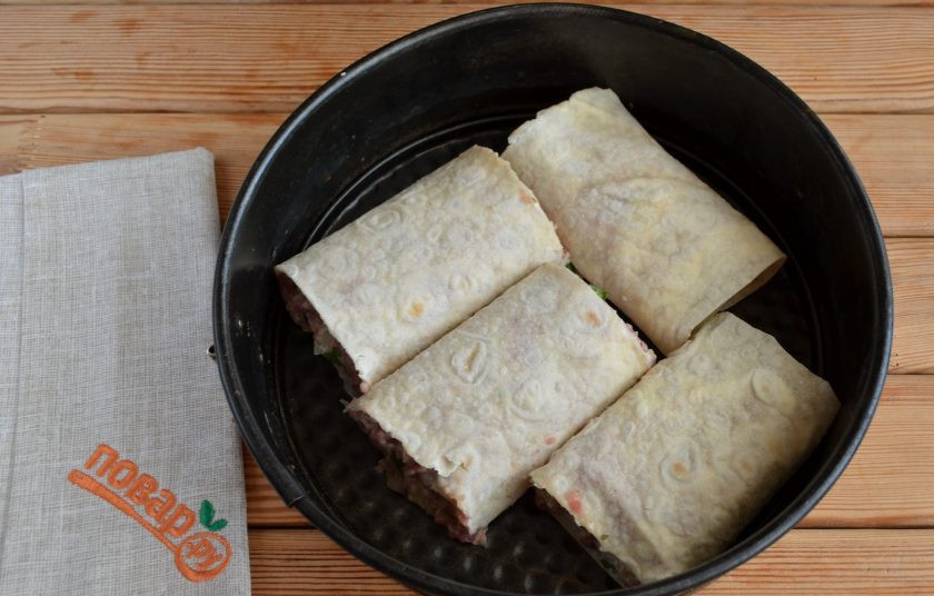 1. Этап. Фарш в лаваше по-провански: Острым ножом порежьте рулет на 4 части, уложите в огнеупорный противень и отправьте запекаться в духовку на 35 минут, температура — 200 градусов. В процессе выпечки смажьте кусочком сливочного масла рулетики, это сделает корочку золотистой и мягкой, аппетитной на вид.