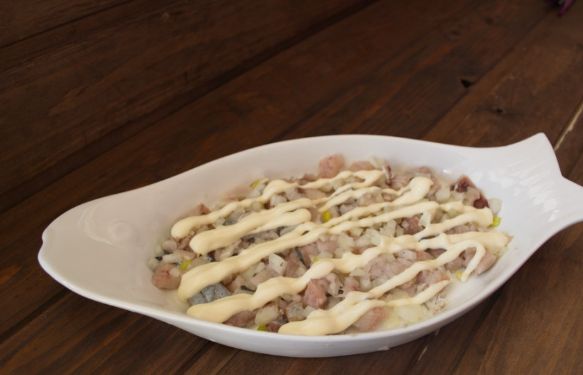 1. Этап. Селедка под шубой классический рецепт: Для приготовления салата сельдь под шубой нам нужно сначала очистить селедку. Нарезать мелким кубиком. Выложить на плоское блюдо. Нарезать мелко репчатый лук. Выложить его поверх селедки. Полить майонезом.