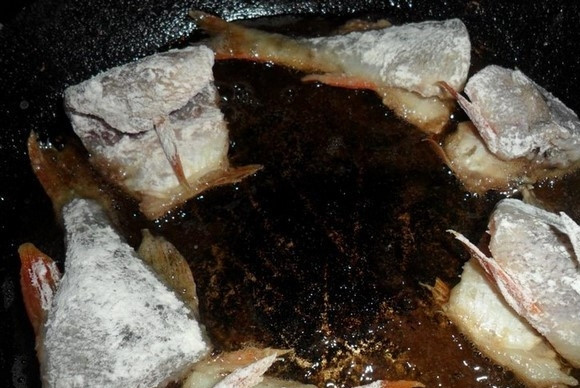 1. Этап. Окунь жареный: Обваляйте окуня в муке. Выложите кусочки на разогретое масло в сковороде.