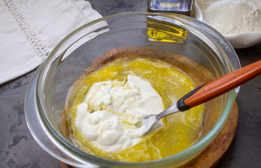 1. Этап. Печенье на сметане в сковороде: Добавьте сметану и растительное масло. Перемешайте.