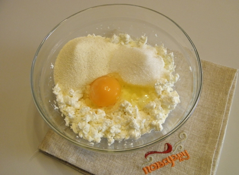 1. Этап. Диетическая творожная запеканка: Возьмите глубокую посудину для смешивания продуктов. Добавьте к творогу яйцо, сахар и манную крупу.