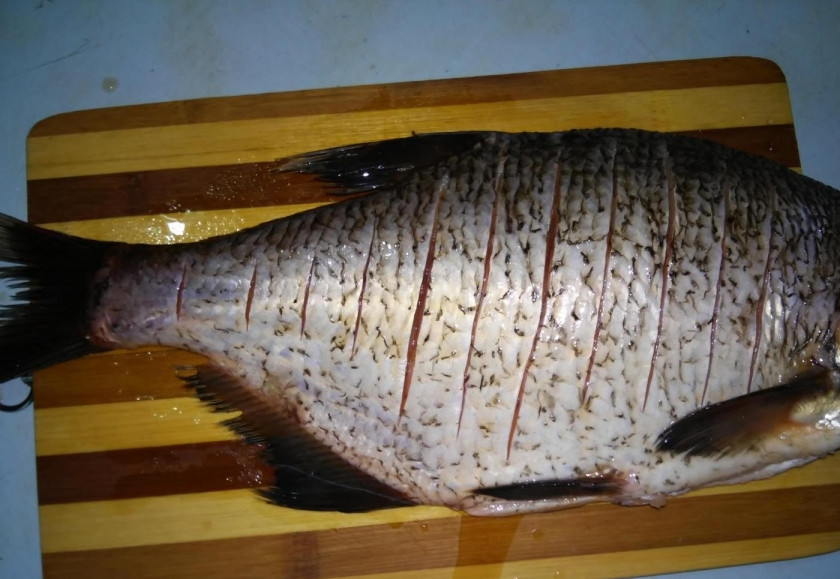1. Этап. Лещ, запеченный в духовке: 1. Лещ у меня довольно крупный. Отрезаю от ткшуи голову и разрезаю брюхо, достаю внутренности и тщательно промываю рыбу (снаружи и внутри). С двух сторон делаю надрезы по всей длине, чтобы рыбка хорошо впитала в себя все соки.
