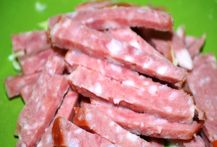 1. Этап. Простой салат с кириешками: Колбасу нарежьте соломкой. Вместо неё можно взять любое копченое мясо – получится еще вкуснее.