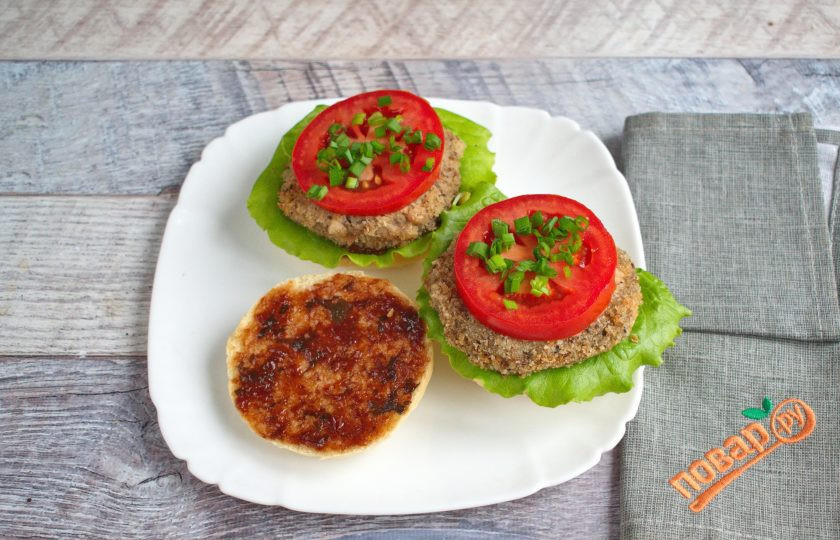 1. Этап. Веганский бургер с грибами: Теперь можно собирать веганский бургер. Половинку булочки смажьте ткемали (или другим соусом на ваш вкус), положите лист салата, овощную котлетку, измельченный зеленый лук, ломтик помидора.