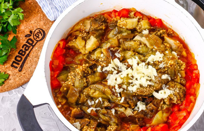 1. Этап. Баклажанная икра без уксуса: Нарежьте баклажанную мякоть ломтиками, выложите в казан. Очистите зубчики чеснока, промойте и спрессуйте их в емкость. Аккуратно все перемешайте и потушите примерно 5-8 минут. Если икра получается слишком густой, то добавьте в емкость немного кипятка. Всыпьте лимонную кислоту и перемешайте, потушите еще 1 минуту.