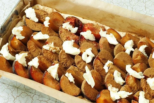 1. Этап. Открытый сливовый пирог: Подошедшее тесто раскатываем в пласт и укладываем в форму для выпекания. Сверху кладем сливы. Сливы присыпаем корицей, сверху выкладываем несколько кусочков сливочного масла.