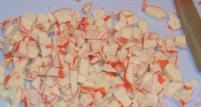 1. Этап. Салат Крабы в шубе: 5. Крабовые палочки достаю из упаковки, ножом нарезаю на небольшие кусочки.