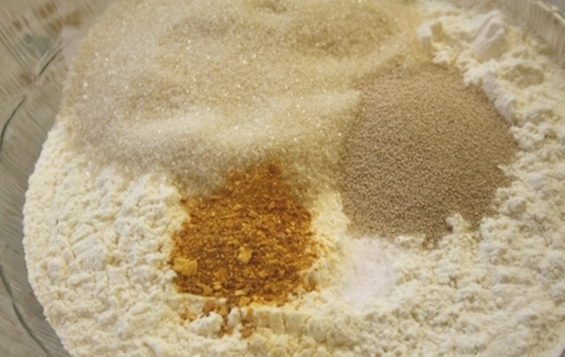 1. Этап. Румынский козунак с творогом: В большой миске смешайте все сухие ингредиенты для теста. Муку следует предварительно просеять через сито. В отдельной миске смешайте молоко с растопленным сливочным маслом, вбейте к ним сырое куриное яйцо.