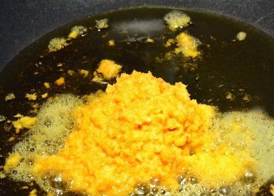 1. Этап. Као Мок Гай: Оставляем в воке примерно 4 столовых ложки масла и разогреваем на среднем огне. Смешиваем измельченный имбирь, чеснок и куркуму и обжариваем эту смесь до появления аромата.