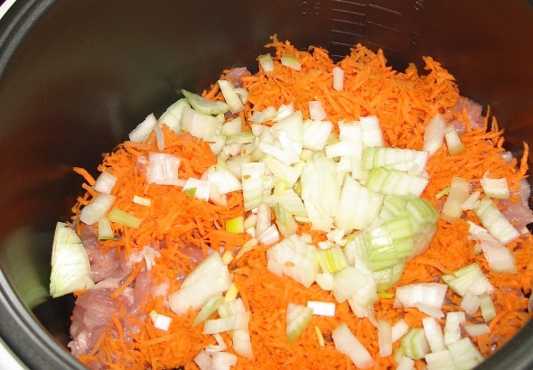 1. Этап. Перловка с мясом в мультиварке: Морковь трем на крупной терке, репчатый лук нарезаем кубиками, выкладываем овощи в мультиварку.