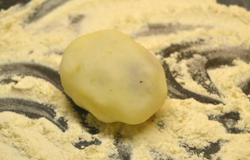 1. Этап. Картофельные зразы с начинкой из фарша: 11. Защипните начинку, чтобы сформировался пирожок. На тарелку насыпьте крахмал (можно муку или панировочные сухари), обваляйте в нем зразы.