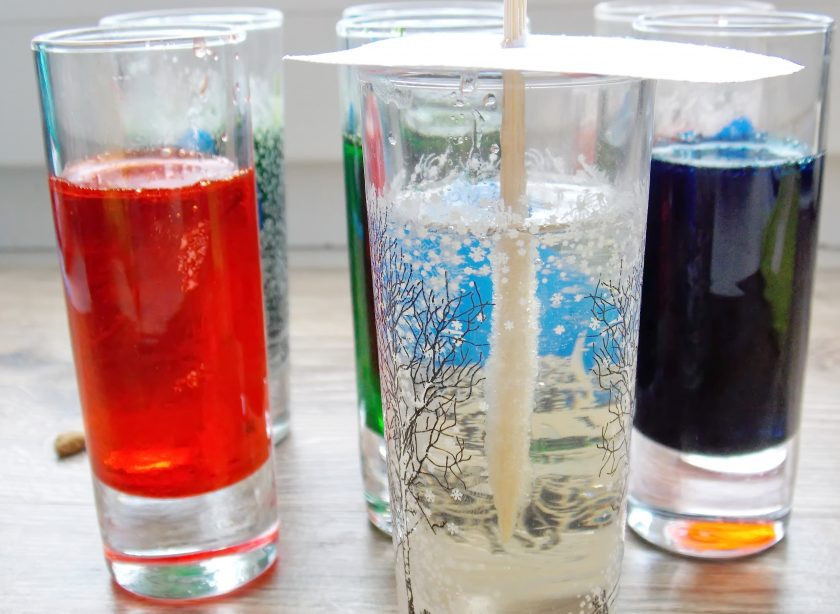 1. Этап. Сахарные кристаллы на палочке: Влейте сахарный сироп и перемешайте до однородного цвета. Из листа плотной бумаги вырежьте круги побольше, чем диаметр стаканов. Проткните круги посередине и опустите сахарной стороной в стаканы. Палочки не должны соприкасаться дна и стенок. Оставляем их так на две недели. Только смотрите, чтобы верх не покрылся коркой, при необходимости разбивайте ее.