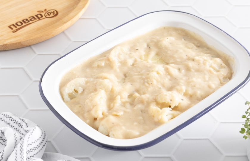 1. Этап. Цветная капуста с картошкой в духовке: Влейте соус. Сверху можно добавить еще тертого сыра. Выпекайте в разогретой до 190 градусов духовке 20-25 минут.