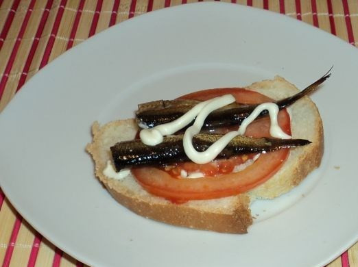 1. Этап. Горячие бутерброды со шпротами и сыром: На каждый кусочек батона кладем чуть майонеза, сверху - помидор и шпроты.