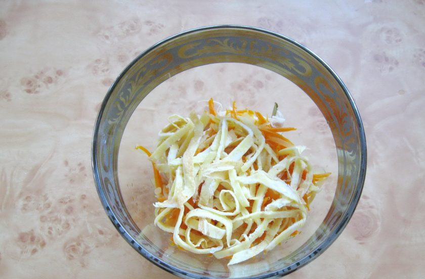 1. Этап. Салат с курицей и лапшой из омлета: Омлет охладите и нарежьте как лапшу. Добавьте в салат.