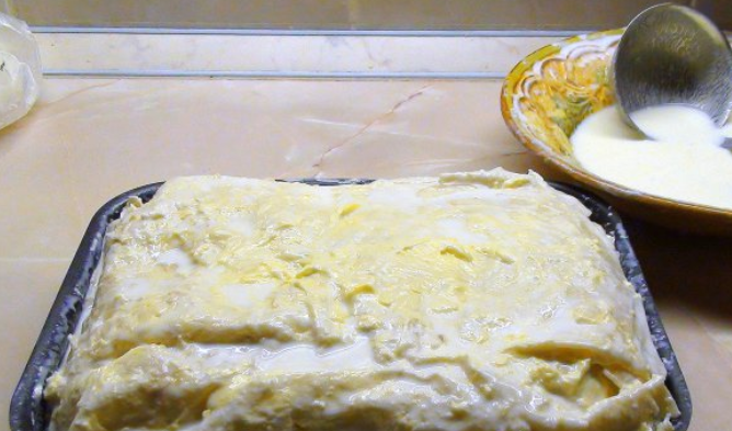 1. Этап. Ачма с сыром и творогом: Повторно выкладываем сырную начинку, масло и кефирную смесь. Накрываем последним листом лаваша (края заправит внутрь). Поливаем остатками масла и кефира с яйцами.