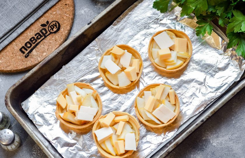 1. Этап. Тарталетки с грушей и сыром: Груши и сыр нарежьте небольшими кусочками, выложите в тарталетки.