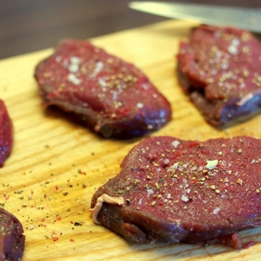 1. Этап. Стейк Диана: Нарезаем говяжью вырезок поперек прожилок на медальоны толщиной 3-4 см. Каждый медальон слегка отбиваем до толщины в 1,5-2 см. Обсыпаем солью и перцем.