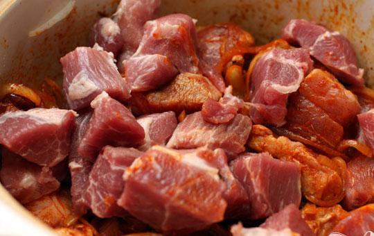 1. Этап. Гуляш из свиной шейки: 2. На мясе срезаем лишний жир, затем нарезаем его кубиками, приблизительно около трех сантиметров, и добавляем в лук. Со всех сторон слегка обжариваем.