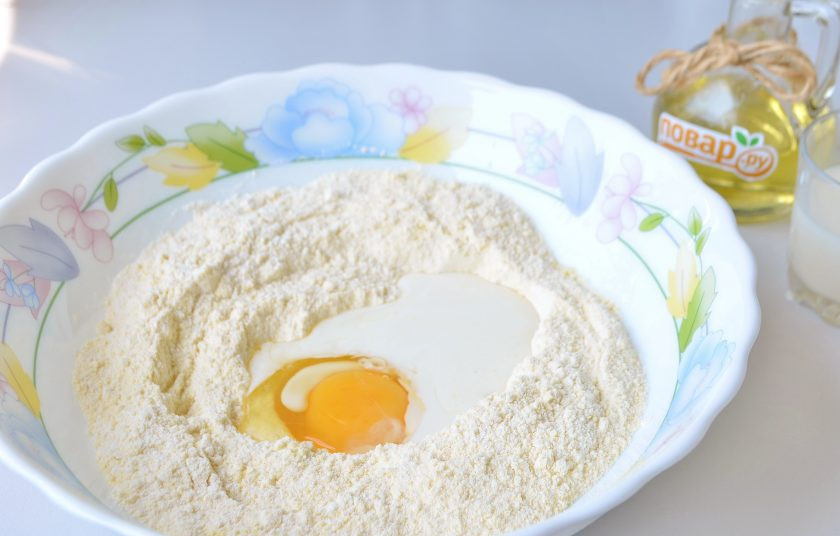 1. Этап. Корн-доги: 3. Вбейте одно крупное яйцо и влейте часть молока. Начните замешивать тесто. По мере надобности вливайте оставшееся молоко. Но, тесто должно быть густым, гуще, чем на оладушки, поэтому не спешите сразу влить все молоко, может понадобится чуть меньше.