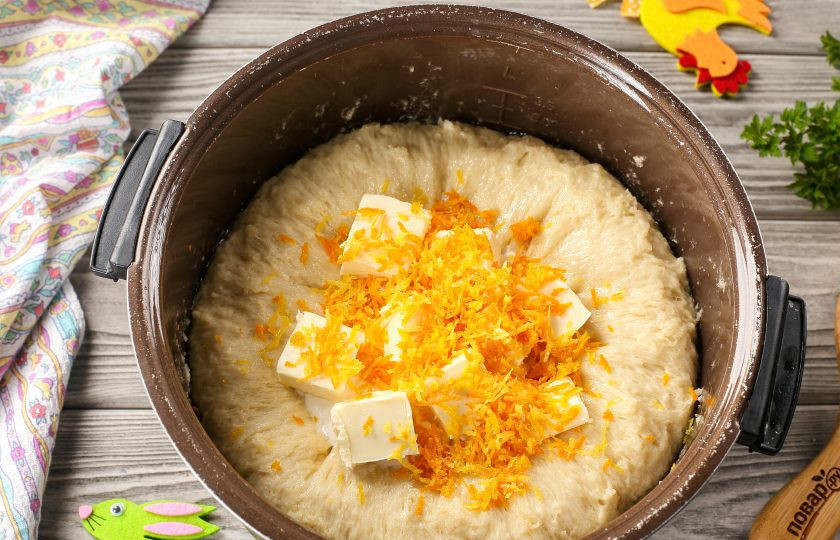 1. Этап. Пасхальный кулич на живых дрожжах: Подошедшее тесто обомните руками. Добавьте сметану, мягкое сливочное масло, цедру лимона и апельсина.