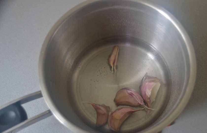 1. Этап. Кальмары в чесночном соусе: Положите в кипящую воду на 1,5 минуты 5 зубчиков чеснока.