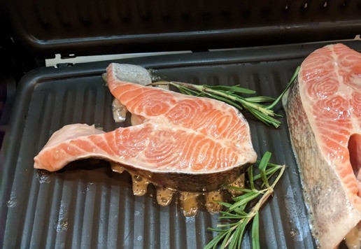 1. Этап. Стейк из лосося с сыром дорблю: Разогрейте гриль до средней температуры, выложите рыбу, положите сверху веточки розмарина. Тем временем, нарежьте сыр кубиками, за 1 минуту до готовности рыбы посыпьте её сыром и расплавьте сыр