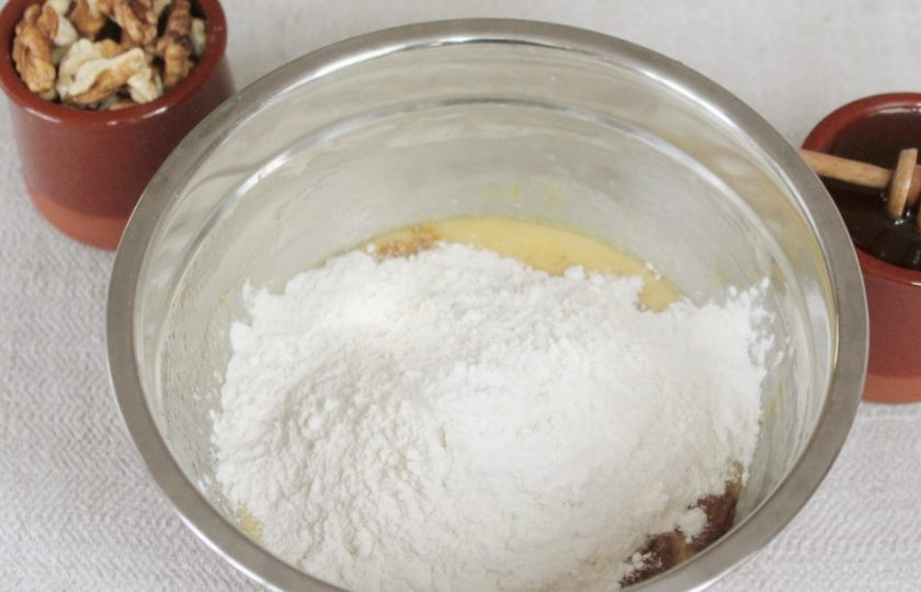 1. Этап. Пряники с грецкими орехами: Добавляем в миску стакан муки и гашенную соду. Перемешиваем. Оставшуюся муку подсыпаем порциями.