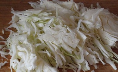 1. Этап. Тушеная капуста с колбасками: Капусту мелко шинкуем, посыпаем солью и помнем - она станет помягче и пустит сок.