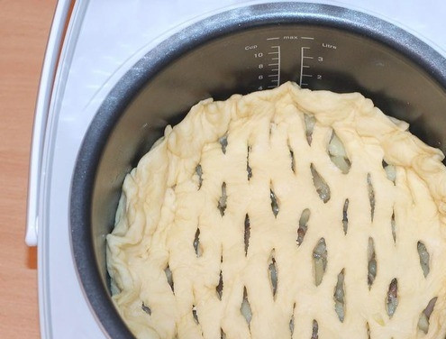 1. Этап. Пирог с картошкой и грибами: Накройте пирог заранее раскатанным вторым куском теста. В нем предварительно следует сделать небольшие надрезы. Закрепите края, чтобы пирог не развалился. Поставьте на режим подогрева и дайте пирогу подняться. Затем в режиме 