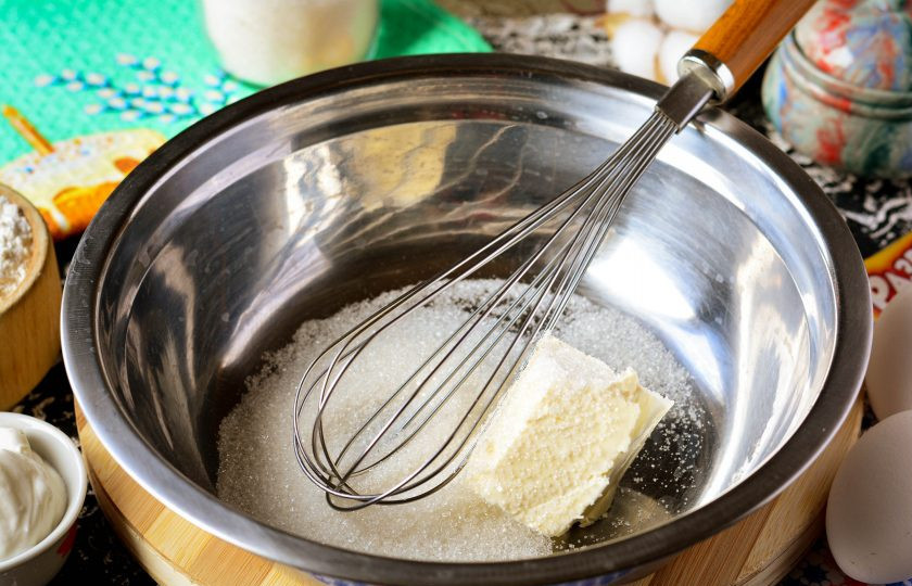 1. Этап. Кулич который не крошится: Всыпьте сахар в глубокую миску, добавьте мягкое сливочное масло комнатной температуры. Разотрите венчиком или используйте миксер.