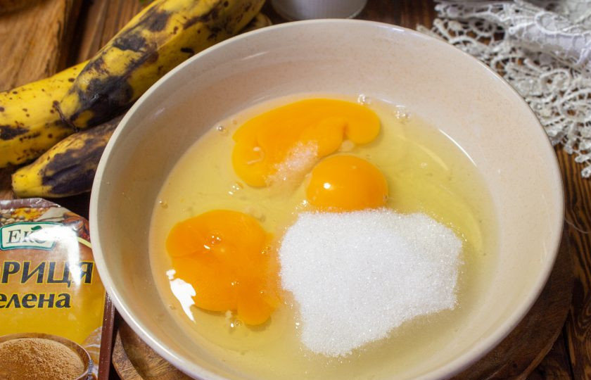 1. Этап. Пирог с бананом на кукурузной муке: В подходящую посуду вбейте куриные яйца, добавьте сахар и перемешайте продукты венчиком.