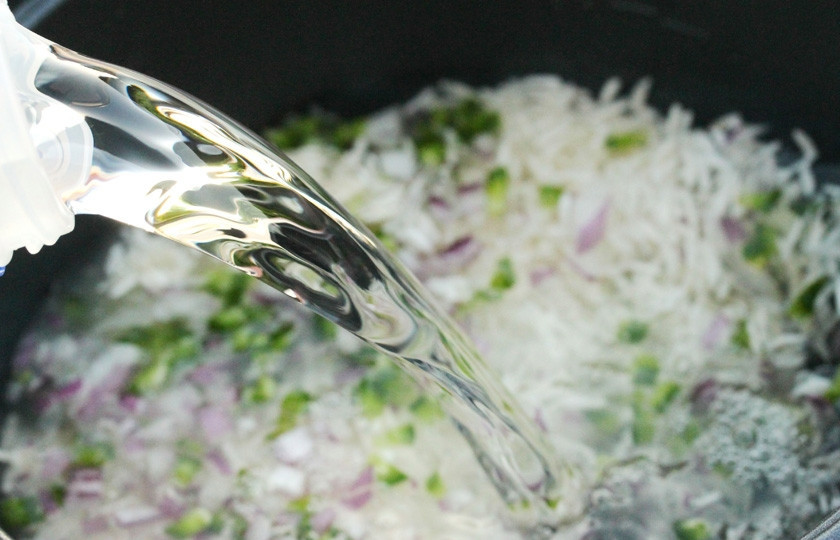 1. Этап. Курица по-японски: Смешайте рис, горький перец и лук. Залейте водой и поставьте на огонь.