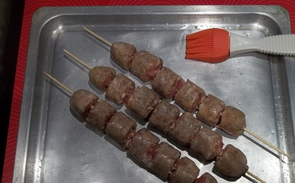 1. Этап. Купаты с картошкой в духовке: 2. Картошку равномерно распределим по противню и отправим в духовку, разогретую до 180 градусов. Колбаски нанизываем на шпажки и нарезаем кусочками. Или сначала нарежем, а потом нанизаем - как кому удобнее.