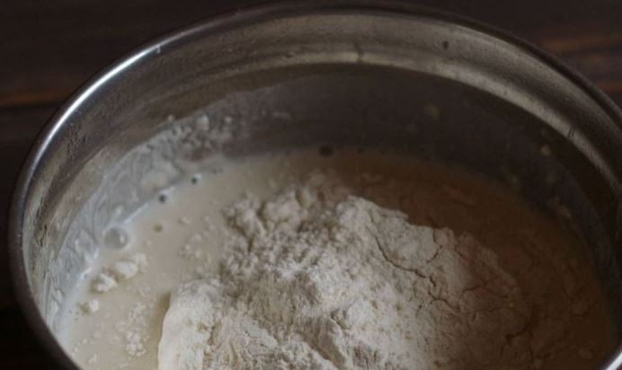 1. Этап. Оладушки на дрожжах и молоке: Затем вбейте в миску сырое куриное яйцо. Тщательно все взбейте. Всыпьте остаток муки, соль и растительное масло без запаха. Перемешайте ингредиенты.