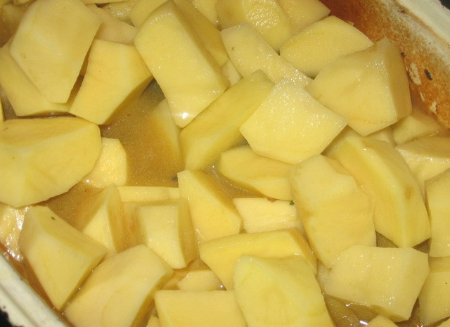 1. Этап. Жаркое из утки в духовке: 4. Картофель очистить, вымыт и нарезать небольшими кубиками. При желании его можно отварить предварительно около 10 минут (в этот простой рецепт жаркого из утки в духовке используется сырой). Выложить в утятницу и залить бульоном. Если под рукой нет бульона, то можно взять воду, однако предварительно ее нужно посолить по вкусу.