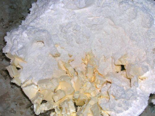 1. Этап. Пицца из песочного теста: 1. Просеять муку в миску и добавить сахар. Мелко нарезать маргарин и перемешать с мукой до консистенции крошек.