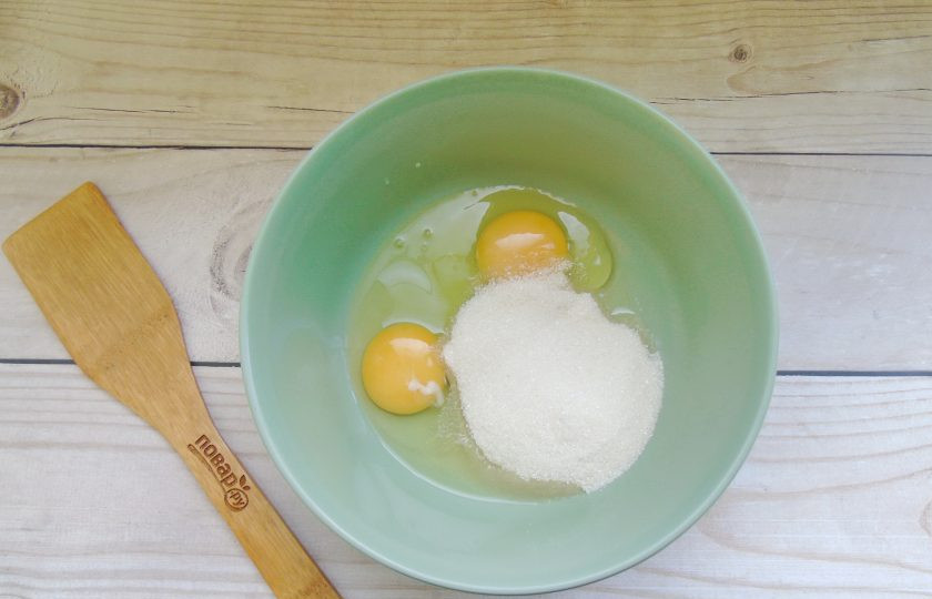 1. Этап. Пирог с тыквой и курагой: Разбейте яйца в миску и насыпьте сахар.