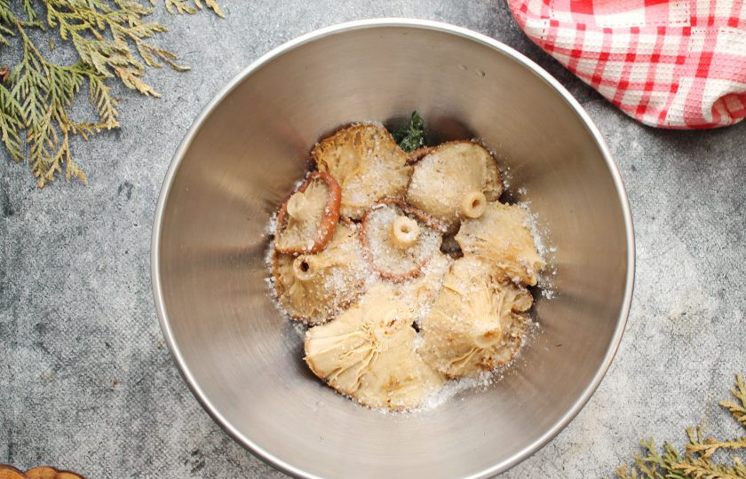 1. Этап. Волнушки соленые: Выложите плотно первый слой волнушек шляпками вниз и пересыпьте солью.