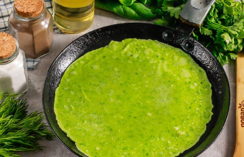 1. Этап. Блинчики шпинатные: Прогрейте блинную сковороду на плите и в первый раз смажьте ее растительным маслом. Влейте часть теста и аккуратно распределите по дну емкости. Испеките примерно 1-2 минуты на умеренном нагреве. Если будете печь на сильном нагреве, то прожарятся края блина, а серединка останется сырой и порвется при переворачивании! Затем переверните на другую сторону и обжарьте еще 1 минуту.