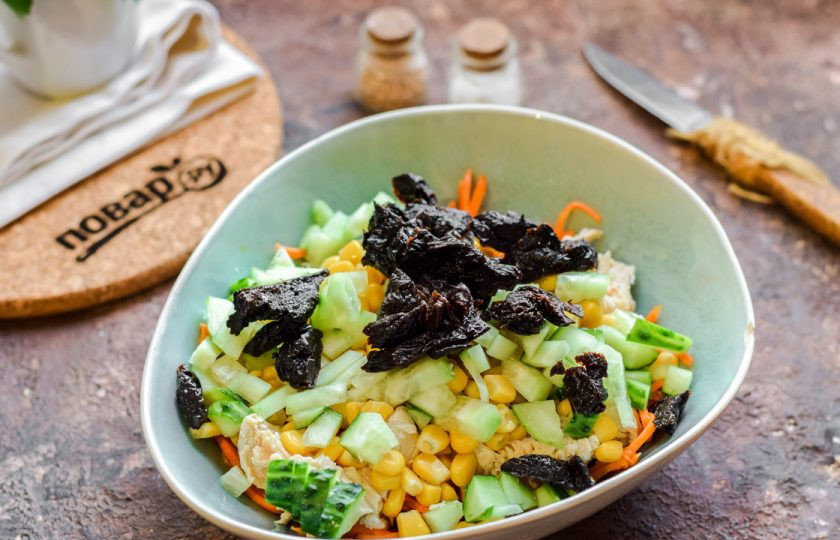 1. Этап. Салат новогодний Фурор: Нарежьте небольшими кубиками свежий огурец и чернослив. Переложите ингредиенты в салат.