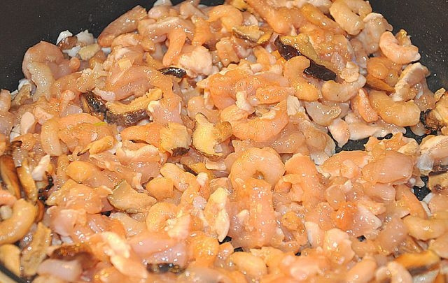 1. Этап. Рисовые роллы: 2. Лук чистим и нарезаем кубиками. В сковороду наливаем подсолнечное масло и обжариваем лук, затем грибы, добавляем замаринованные креветки с куриным филе, перемешиваем и тушим все 2-7 минут.