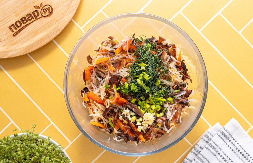 1. Этап. Салат из фунчозы и китайских древесных грибов: Переложите салат в глубокую миску, заправьте соевым соусом и кунжутным маслом. Добавьте молотый острый перец, мелко нарезанную зелень и измельченный чеснок. Все перемешайте и дайте салату настояться 10 минут.
