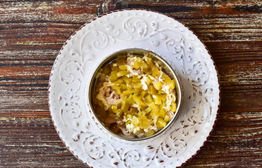 1. Этап. Оливье с ананасом: Вторым слоем выложите соленый огурец.