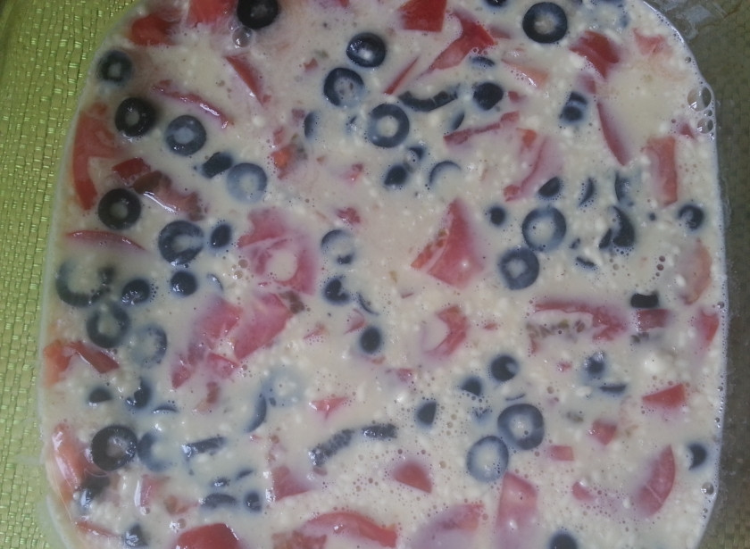 1. Этап. Омлет в духовке с мукой: Форму для омлета смазать сливочным маслом. Выложить слой помидоров, смешанный с рубленными маслинами и залить все смесью.