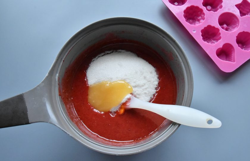 1. Этап. Конфеты из замороженной клубники: Масса начнет быстро густеть. Добавьте в кастрюлю оставшийся сахар и мед. Продолжая мешать, варите ягодную массу еще 3-4 минуты. Температура смеси должна достигнуть 106 градусов. Если у вас нет кулинарного термометра, ориентируйтесь на интенсивность кипения и наличие пузырей.