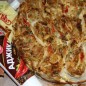 Капустный пирог из лаваша Спассеровать на растительном масле лук, добавить морковь, болгарский перец и сельдерей. Немного потушить. Добавить капусту, посолить. Потушить. За 5 минут до выключения добавить специи, зелень. Прогреть. Овощная часть начинки готова. Вареную курицу разобрать на волокна или мелко нарезать, посолить. Обжарить на сковороде с добавлением аджики. Обе составляющие начинки объединить и перемешать. Выложить равномерно на лаваш и свернуть рулетом. Нарезать рулетики шириной, не превышающей высоту стенки формы, где будет запекаться пирог. Форму размером 22 см застелить бумагой для выпечки (у меня она разъемная, чтобы не вытекала заливка), уложить рулетики в форму. Приготовить заливку для пирога, смешав все компоненты.
