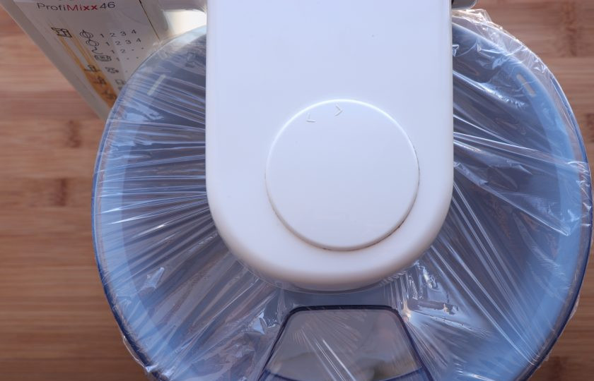 1. Этап. Домашнее масло из сметаны: Перелейте сметану в чашу комбайна. Чашу со сметаной затяните пищевой пленкой, в процессе приготовления масла будет отходить жидкость и сильно разбрызгиваться. Начинайте взбивать сметану на маленькой скорости и постепенно увеличьте до максимальной. Сначала сметана станет пышной, а уже примерно через 15 минут, на ее поверхности начнут появляться желтые крупинки. Продолжайте взбивать, пока от масла полностью не отделится вся жидкость, называемая пахтой.