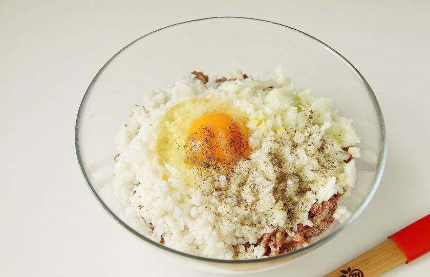 1. Этап. Тефтели в томатно-сливочном соусе: Добавьте к нему отваренный до полуготовности рис, нарезанное мелкими кубиками лук, яйцо, соль и перец по вкусу.